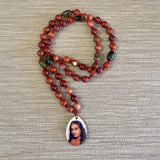 Necklace with multicolored beads and a pendant with a portrait on a textured surface