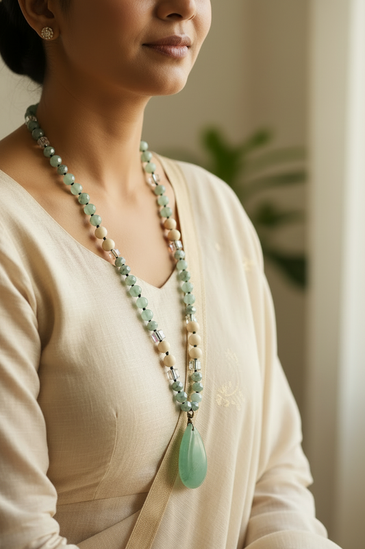Beaded necklace with a green pendant on a wooden surface