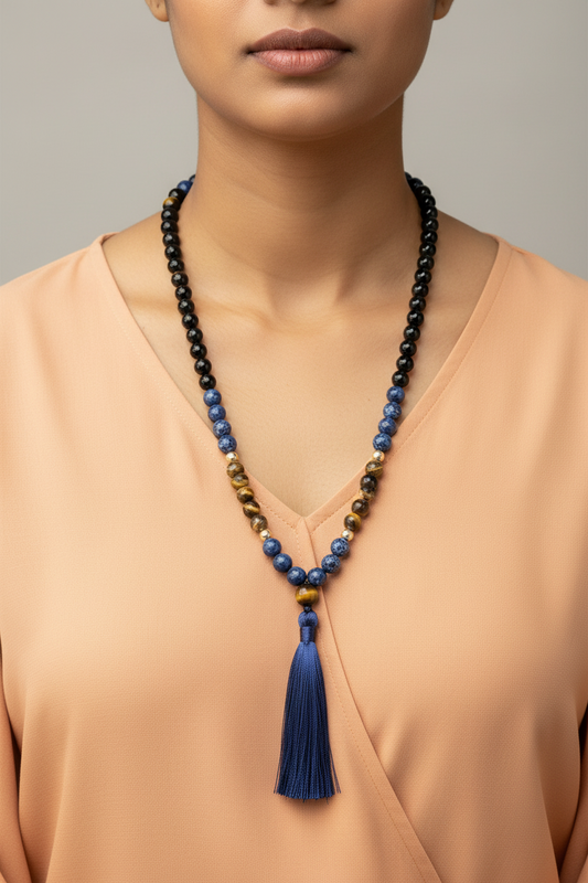 Necklace with blue tassel worn by a person against a neutral background