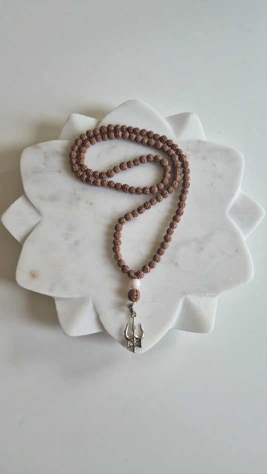 Silver Trishul pendant and pearl detail on rudraksha mala