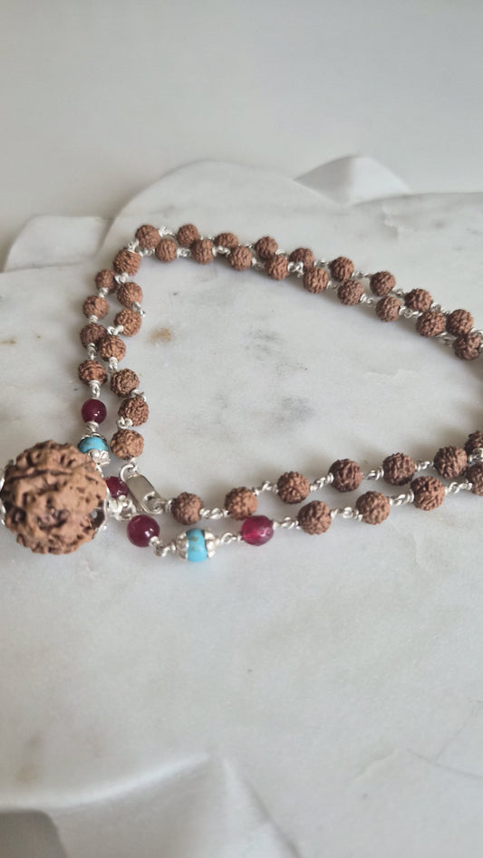 Turquoise and pink beads with carved rudraksha guru bead
