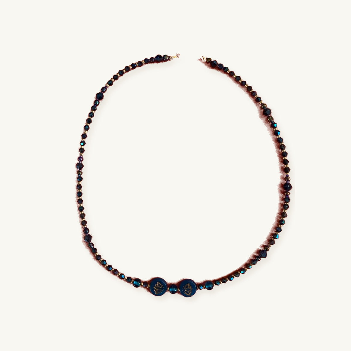 Blue Lotus Beaded Necklace with Two Gold-Etched Lotus Beads, photographed on ivory